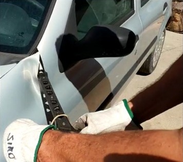 Gloved operator testing the Strikeback near a vehicle door