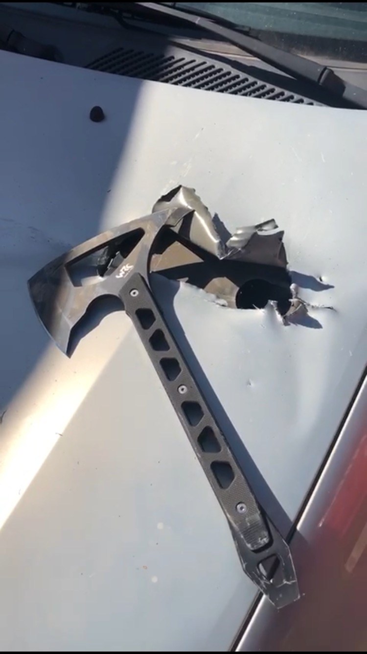 Strikeback resting on a vehicle bonnet beside a pierced metal panel